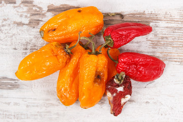 Old moldy peppers on old rustic board, unhealthy and disgusting vegetable