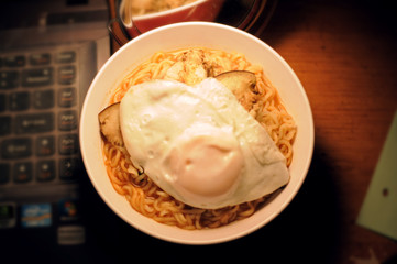 A bowl of egg ramen noodles on work desk