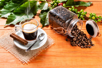 Glass of clear glass of hot coffee on wooden table. Orange wood pinus.