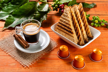 Glass of clear glass of hot coffee on wooden table. Orange wood pinus.