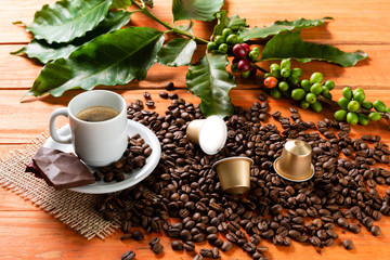 White cup of hot coffee on wooden table. Orange wood pinus.