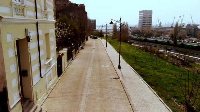 Aerial drone shot in Spring of Ovidiu street in Constanta, near the  with the shipyard and car traffic on the right and houses on the left