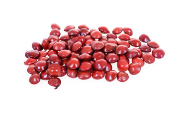 Red sandalwood seeds (Adenanthera pavonina) seeds on white background.