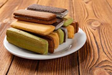 multicolor sandwich cookies on a wood table with copy space