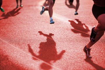 Shadows of runners racing around the curve