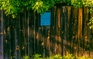 Blue mailbox on a wooden fence