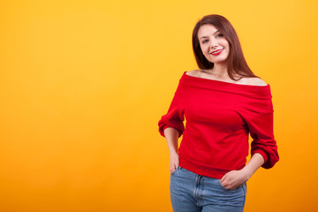 Cheerful young woman with braces with casual clothes over yellow background