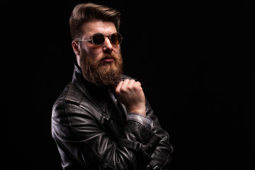 Fototapeta na wymiar Attractive bearded man with styish glasses over black background