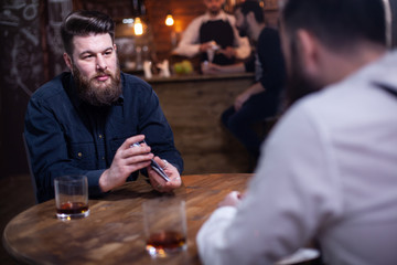 Attractive bearded men drinking whiskey in a pub