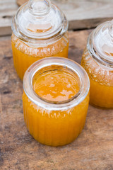 Farm natural organic honey in glass jar on wooden table with spoon. Open and closed jars. Golden sticky honey nectar. Healthy food. Close up