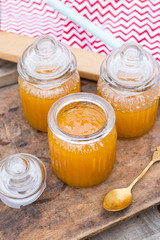 Farm natural organic honey in glass jar on wooden table with spoon. Open and closed jars. Golden sticky honey nectar. Healthy food. Close up