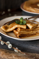 Homemade thin crepes with honey, pancakes on wooden rustic background
