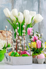 Easter floral decoration with catkins, painted eggs and flowers.