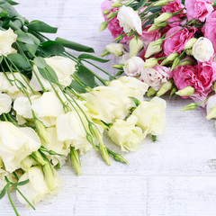 Pink and yellow eustoma (lisianthus) flowers on table.