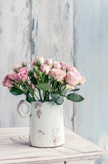 Bouquet of pink roses in ceramic vase.