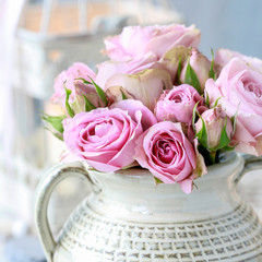 Bouquet of pink roses in ceramic vase.
