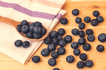 Bilberries on a wooden spoon and near.  Concept of healthy nutrition. Selective focus.