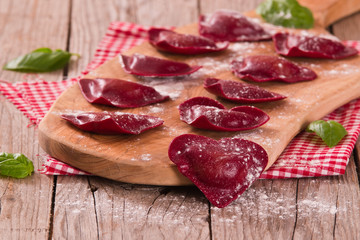 Red heart ravioli with tomato, mozzarella and basil.
