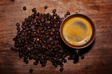 cup of coffee and beans on wooden background