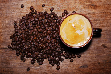 cup of coffee and beans on wooden background