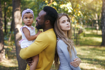 Pretty dark-skinned girl, father and mother in the park.