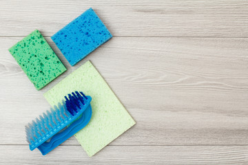 Synthetic sponges, microfiber napkin and brush for cleaning on wooden boards.