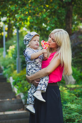 Cute little girl with her mother eating colorful lollipop.