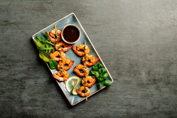 Fototapeta na wymiar Delicious roasted shrimps on plate with lemon