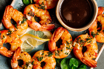 Delicious roasted shrimps on plate with lemon