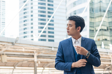 Young businessman adjusting cufflink his blue suit.