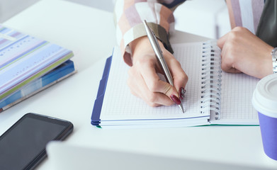 Top view of business woman hands making notes with silver pen in office background. Business...