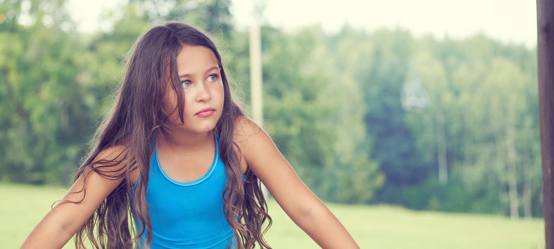 Caucasian little girl with long hair in swimsuit. Happy child