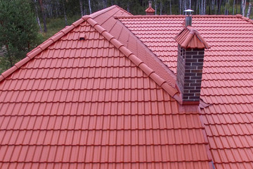 Roof with red tiles and brick pipe