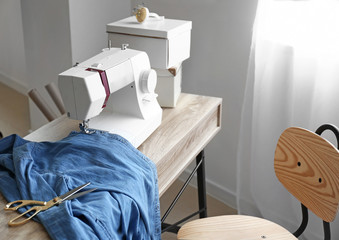 Sewing machine on tailor's workplace in atelier