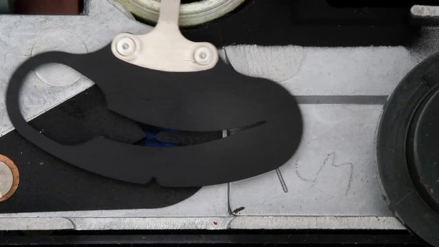Automatic aperture control over lens in cine camera controlled by power from selenium cell light meter.