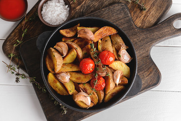 Frying pan with tasty baked potato on table