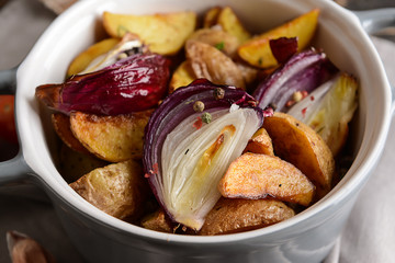 Pot with tasty baked potato on table, closeup