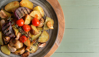 Plate with tasty baked potato on table