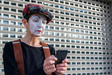 mime looks at the mobile phone with a worried face