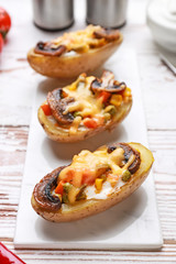 Tasty baked potato on white wooden table