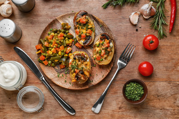 Plate with tasty baked potato on wooden table