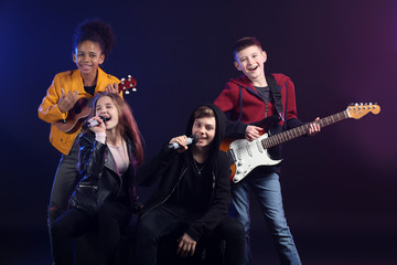 Fototapeta premium Band of teenage musicians on dark background