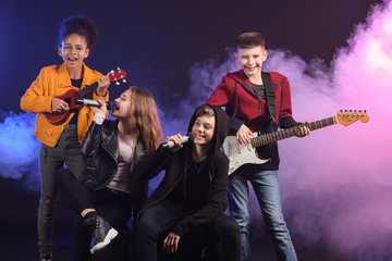 Fototapeta na wymiar Band of teenage musicians on dark background