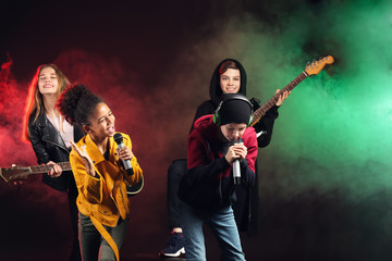 Obraz premium Band of teenage musicians on dark background