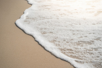 sea wave with bubbles on the sand beach