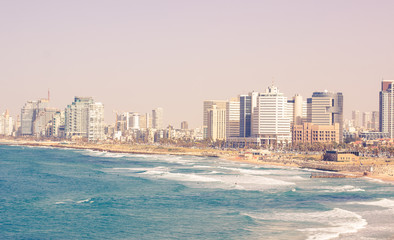 Naklejka premium Tel Avivi Israel capital city view Mediterranean sea waterfront sand beach along vivid blue water with waves and high skyscrapers buildings, summer travel and vacation wallpaper concept