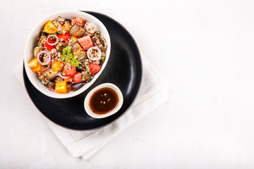 Quinoa salad with roasted eggplant, fresh tomatoes and red onion.   Vegan or vegetarian food. Healthy salad in bowl served on white table. Top view, copy space.