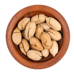Pecan nuts in a ceramic bowl isolated on white background.