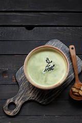 Creamy soup puree with spinach on a dark background