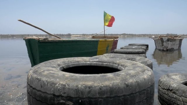 Cinematic shoot of a boat in pink lake of senegal with smooth crane stabilization.